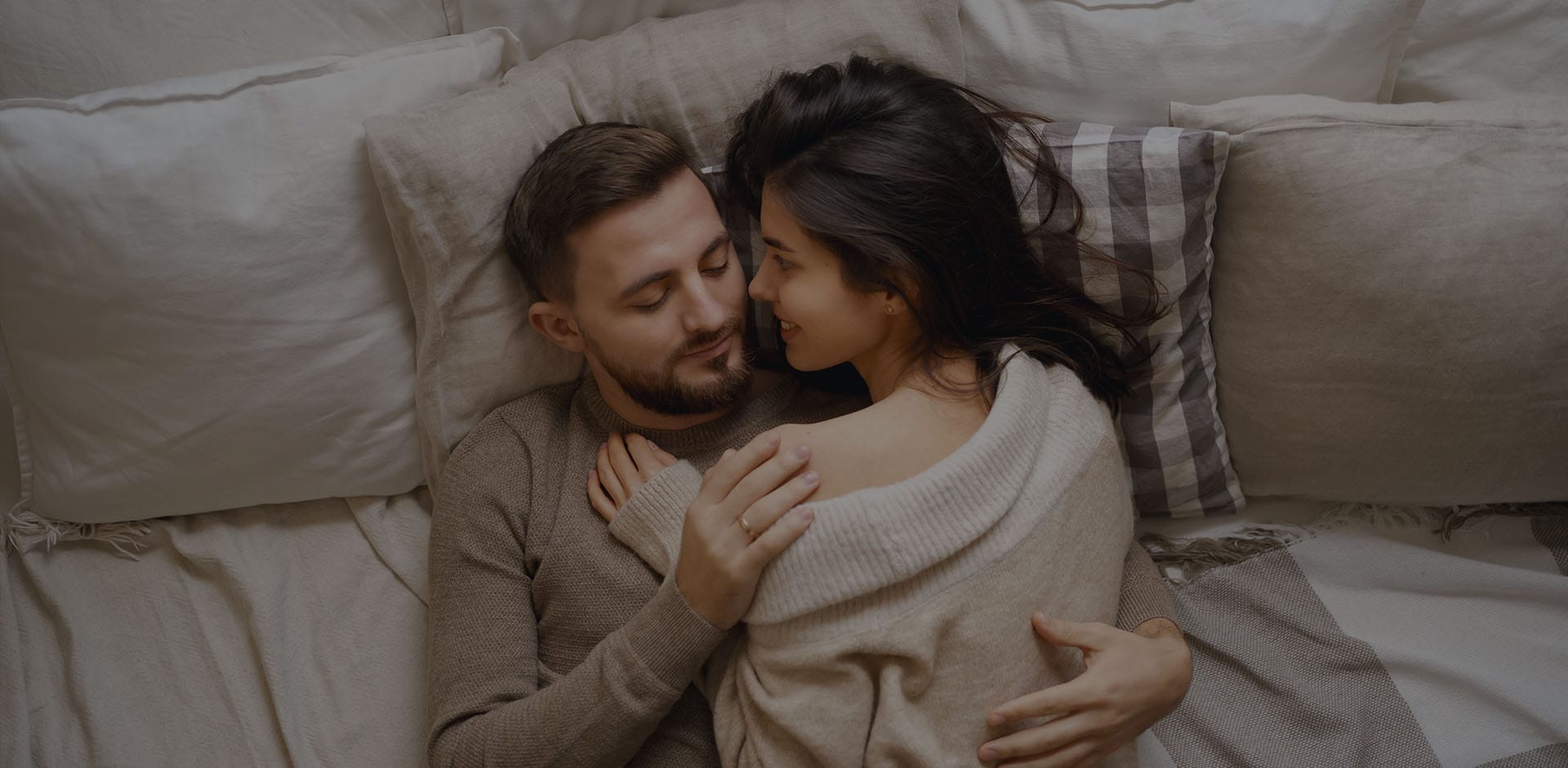 Couple lying together in bed, relaxed and close