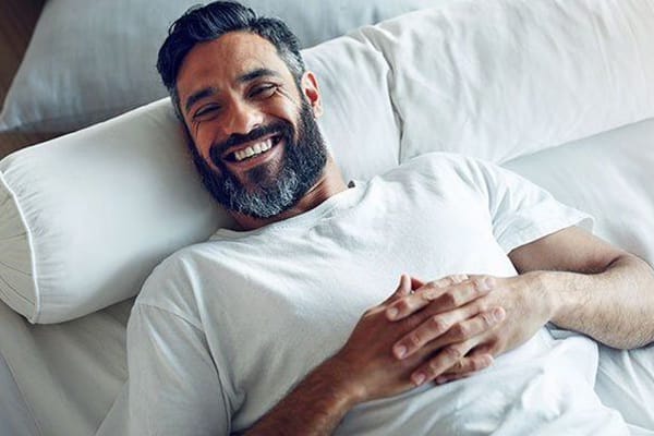 Relaxed, smiling man lying in bed